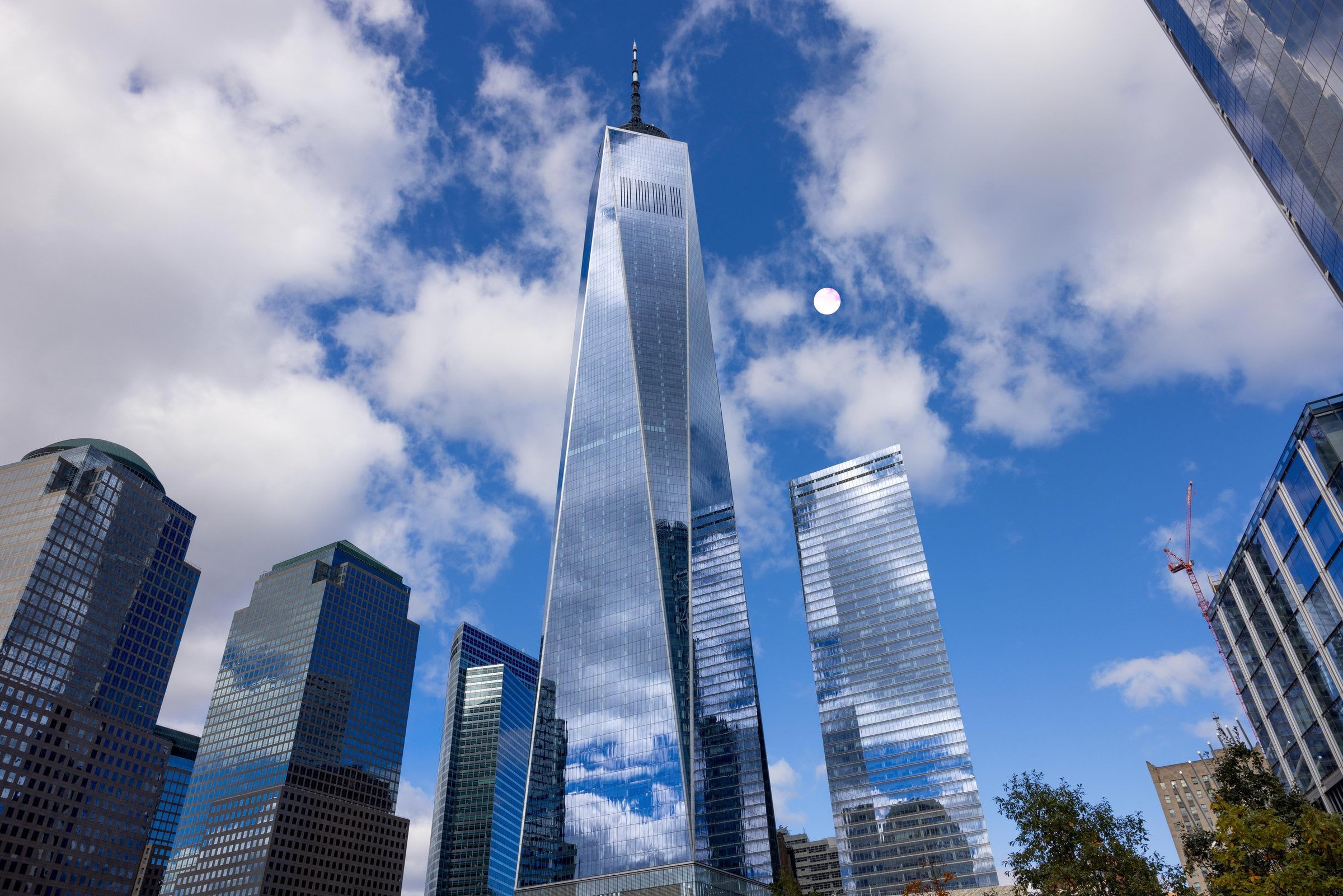 Glass towers reflecting clouds beneath a blue sky