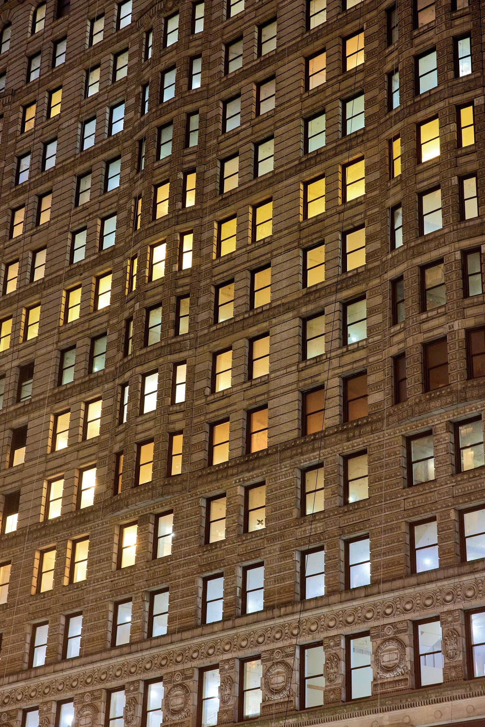 Rows of illuminated windows across an ornate stone building