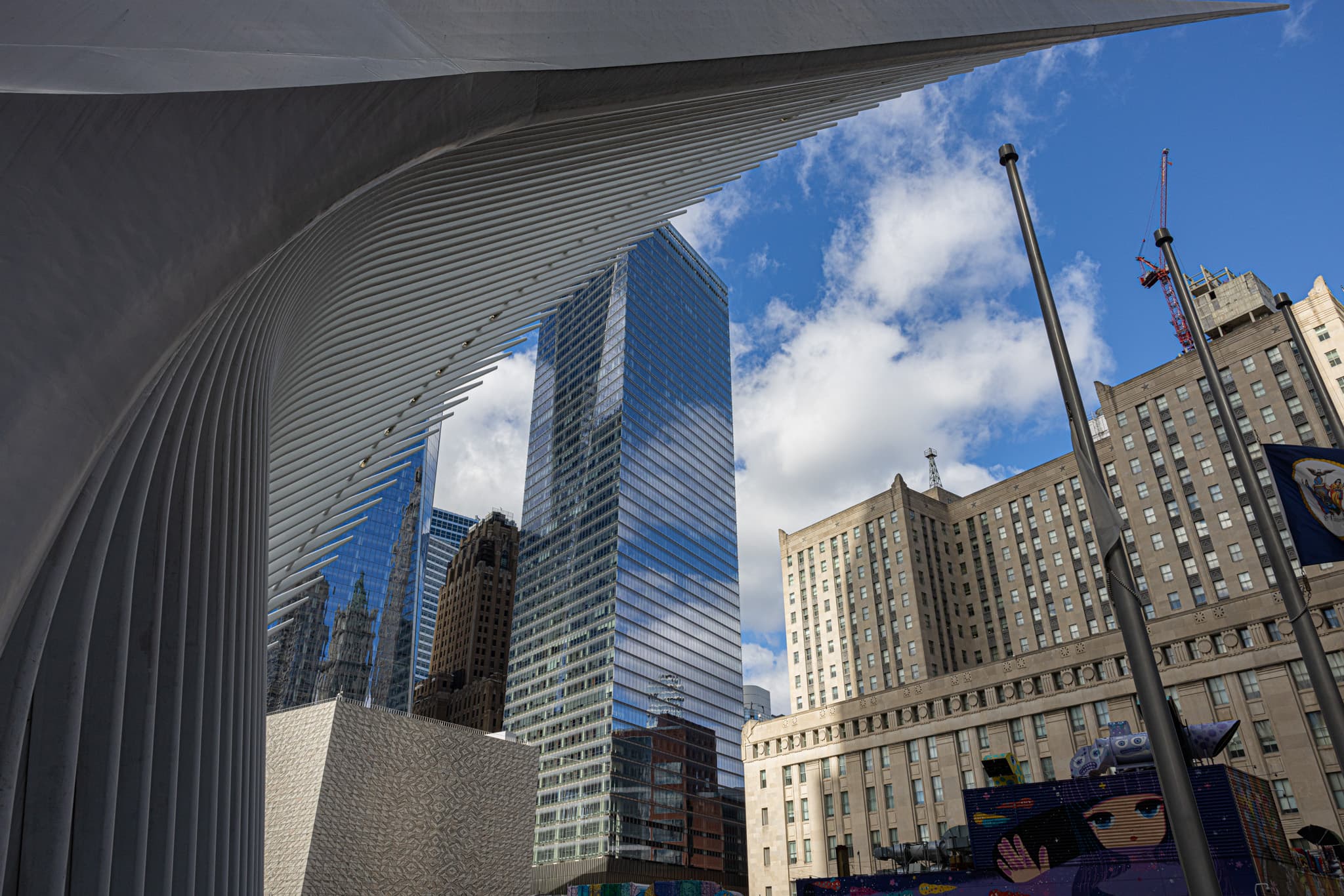 White ribbed canopy framing glass towers against a blue sky